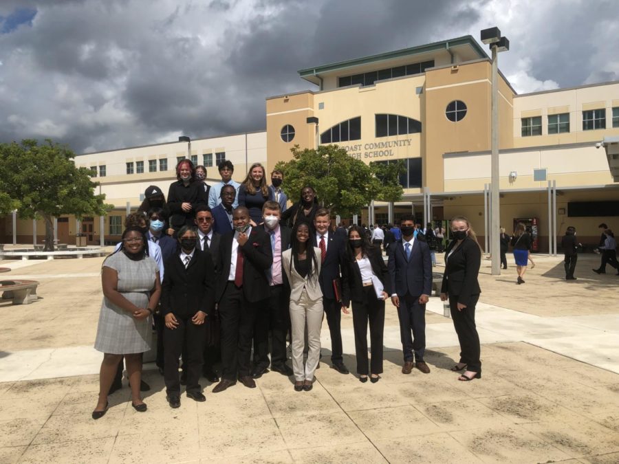 Suncoast+Speech+and+Debate+Team+poses+for+a+group+photo+outside+of+their+school+before+the+start+of+a+tournament.+