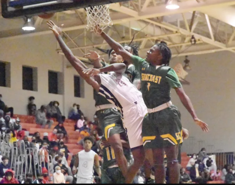 The Suncoast Varsity Basketball teams playing in a heated games against Dwyer High School. Point guard, Stone Bureau, blocks an attempted lay-up.