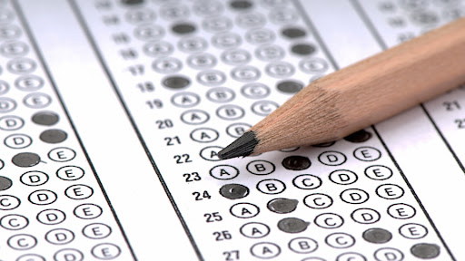 A person bubbles in a scantron for a test. 